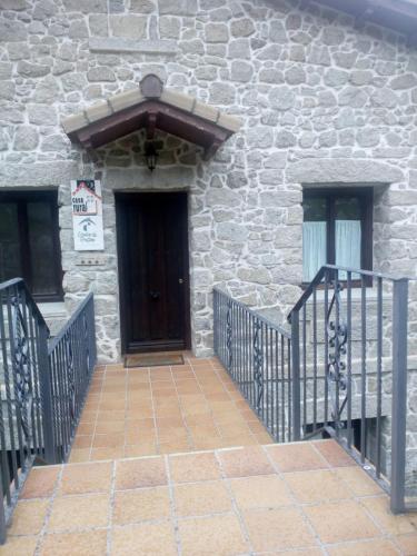 - Entrada a un edificio de piedra con puerta de madera en Casa Rural del Médico I y II, en Herradón de Pinares