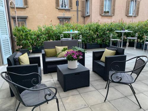 a patio with chairs and a table with flowers at Le 5 Vie in Bergamo