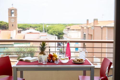 a table with fruit and a book on a balcony at Residence Mediterraneo in Marina di Grosseto