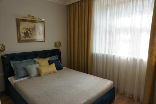 a bedroom with a bed and a window with curtains at Heart of Vilnius Apartment in Vilnius