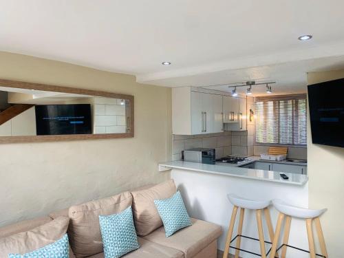 een woonkamer met een bank en een keuken bij The Loft@Santorini in Pretoria