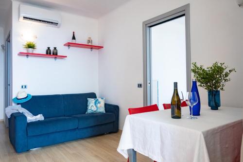 a living room with a blue couch and a table at Residence Mediterraneo in Marina di Grosseto