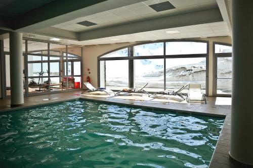 a bathroom with a large pool of water with windows at Résidence Mer & Golf Pic du Midi in La Mongie