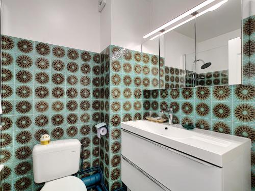 een badkamer met een wit toilet en een wastafel bij Plein Sud in Royan