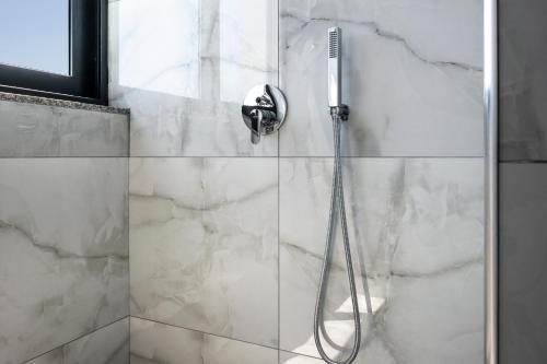 a shower with a shower head in a bathroom at Wait 'n Sea in Himare