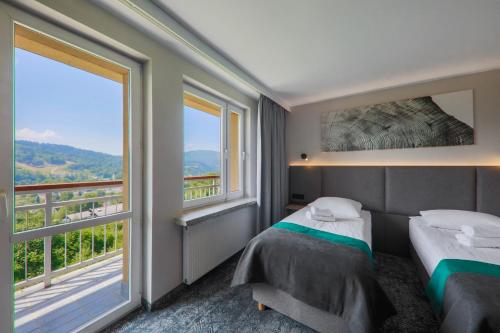 Un pat sau paturi într-o cameră la Hotel Pod Jedlami
