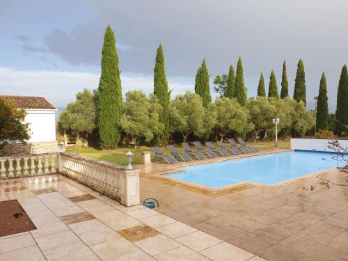 - une piscine dans une cour avec des chaises et des arbres dans l'établissement Domaine d'Herminis - Gîte de Dame Carcas, à Carcassonne