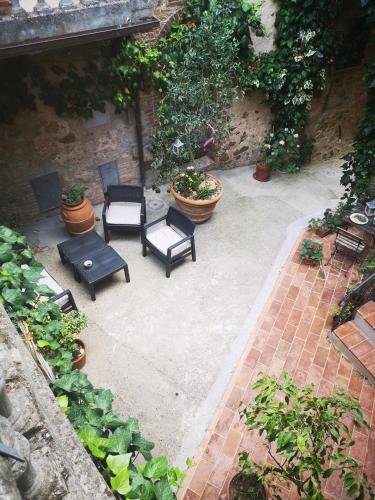 an outdoor patio with chairs and tables and plants at Antico Borgo di Torri in Sovicille