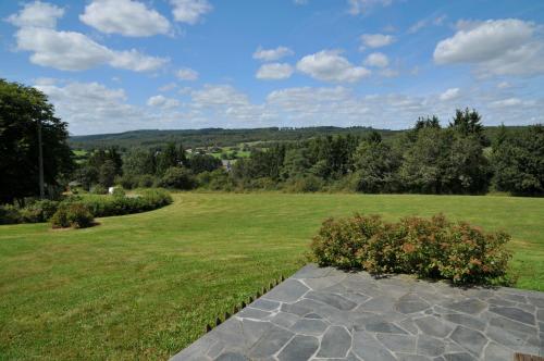 a large grassy field with a stone walkway at Gite Bouton d'Or in Heure
