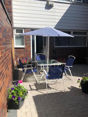 a table and chairs under an umbrella on a patio at Sunderland Self Catering 4 - City Centre Townhouse with free parking in Sunderland