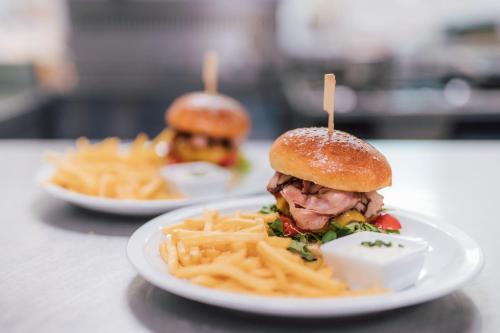 dois pratos de comida com uma sanduíche e batatas fritas em Hotel Pod Zámkem em Vranov nad Dyjí