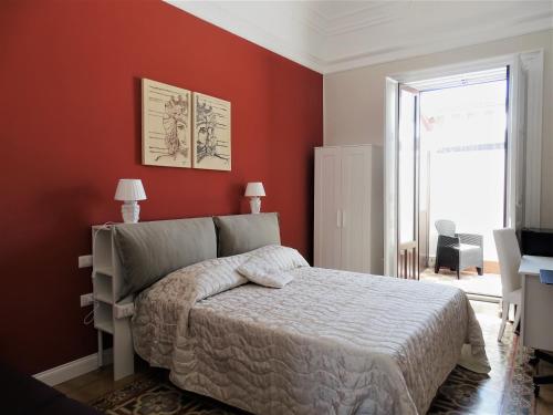 una camera da letto con un letto e una parete rossa di Sogno Etneo a Catania