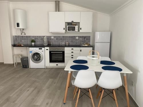 a kitchen with a table and some white appliances at Casinhas da Avó Aura in Reguengos de Monsaraz