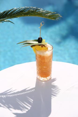 a drink sitting on a table next to a pool at Palace Hotel & SPA in Durrës