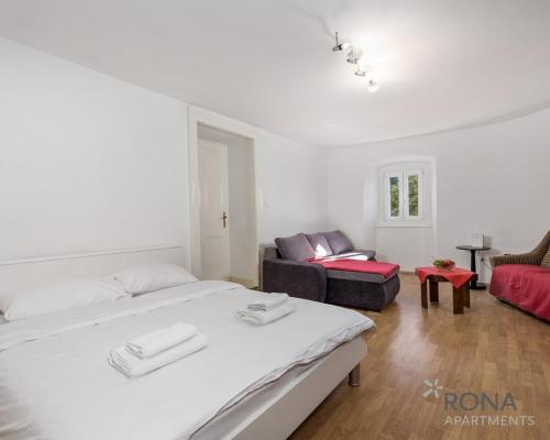 a white room with two beds and a couch at Rona apartment More in Lovran