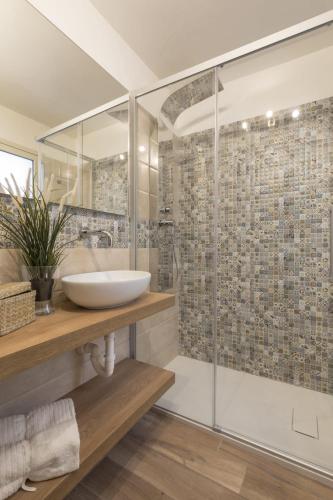 a bathroom with a glass shower and a sink at A vista ri luocci in Modica