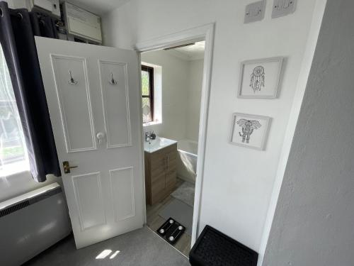 a bathroom with a white door and a sink at WindyS Basildon Smart Home in Basildon