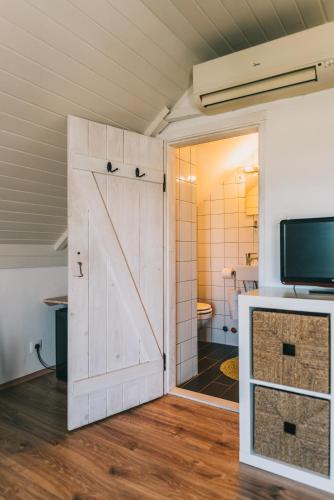 a sliding barn door in a room with a bathroom at Óbester Panzió in Badacsonytomaj
