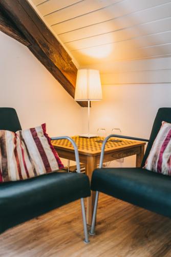 a room with two chairs and a table with a lamp at Óbester Panzió in Badacsonytomaj