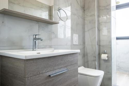 a bathroom with a sink and a toilet at Wait 'n Sea in Himare