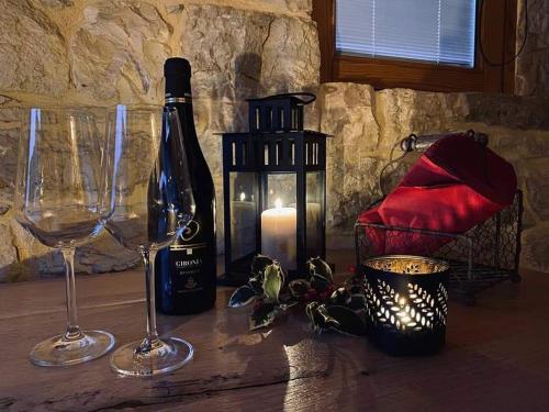 uma mesa com uma garrafa de vinho e dois copos em B&B Il Fabbro Chambre em Castelmauro