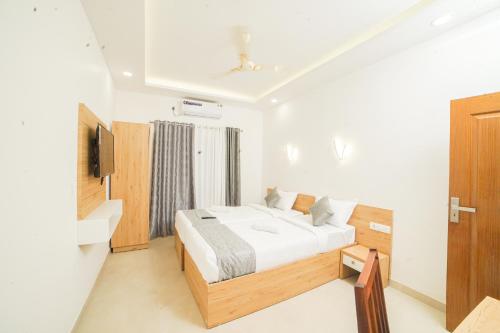 a bedroom with a bed and a television in it at Oceana Hills Residency in Alleppey