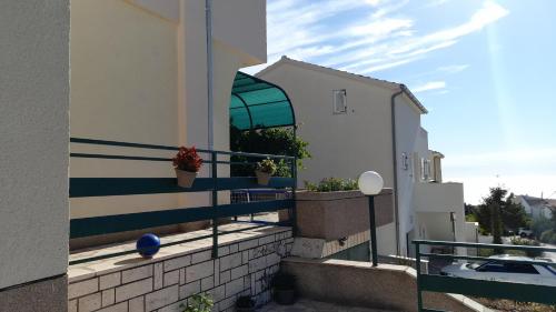 a balcony with potted plants on the side of a building at Apartments Dolac in Primošten