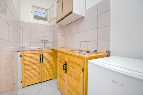 a small kitchen with yellow cabinets and a sink at Davidovic Apartments in Herceg-Novi