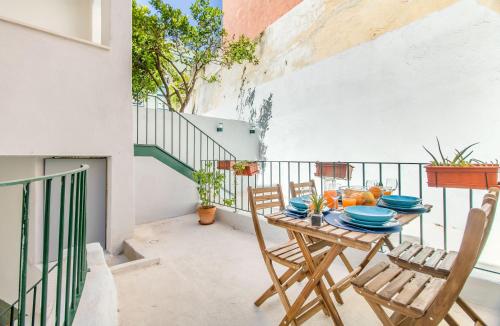 eine Terrasse mit einem Tisch und Stühlen auf dem Balkon in der Unterkunft Olarias Terrace Lisbon in Lissabon