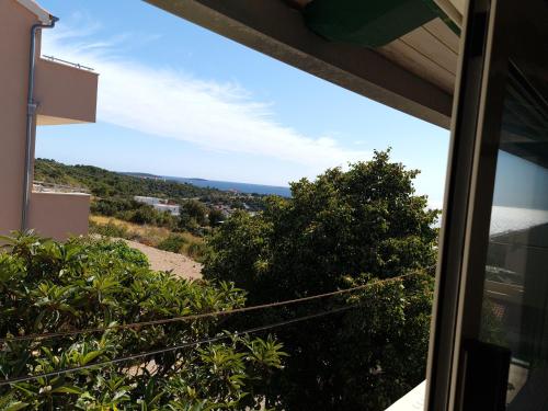 a view of the ocean from a house window at Apartments Dolac in Primošten