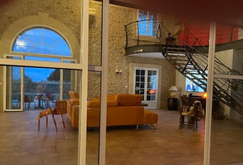 a living room with a couch and a staircase at Chambres d'hôtes la Soulenque Luxury B & B in Capestang