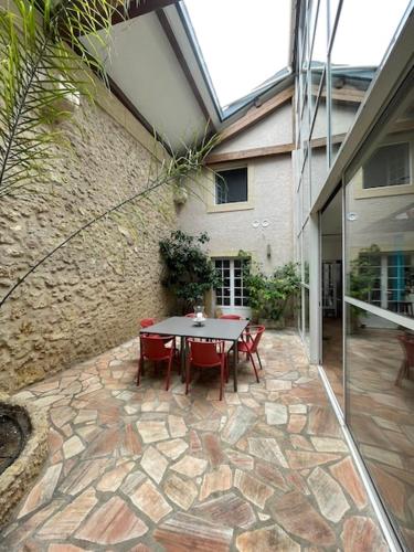 a patio with a table and chairs in front of a building at Chambres d'hôtes la Soulenque Luxury B & B in Capestang