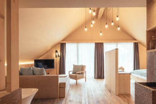 a living room with a couch and a bed and a television at Tirolerhof in San Leonardo in Passiria