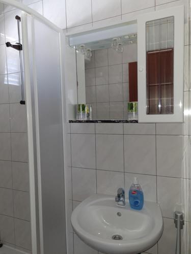 a white bathroom with a sink and a mirror at Apartments Dolac in Primošten