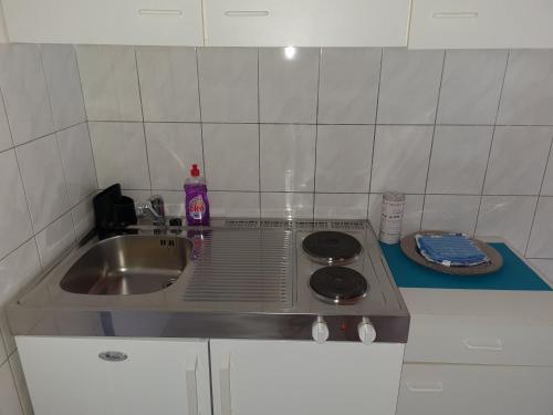 a small kitchen with a sink and a stove at Apartments Dolac in Primošten