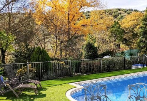 un patio con una valla junto a una piscina en Casa Margarita, en Algarinejo
