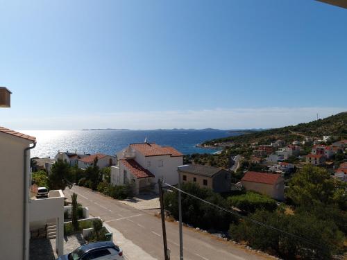 a view of a town on a hill with the ocean at Apartments Dolac in Primošten