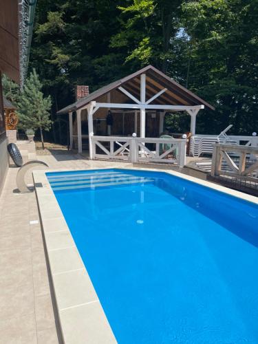 a blue swimming pool with a gazebo at Chalet Mlyn in Migovo