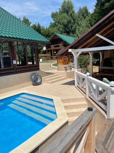 a swimming pool in a yard with a house at Chalet Mlyn in Migovo