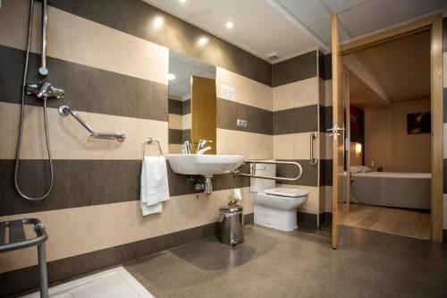 a bathroom with a sink and a toilet and a shower at Hotel Ciudad De Ejea in Ejea de los Caballeros