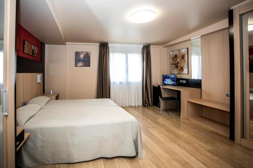 a hotel room with a bed and a desk at Hotel Ciudad De Ejea in Ejea de los Caballeros