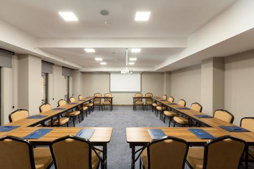 an empty classroom with tables and chairs and a whiteboard at Biography Design Tbilisi in Tbilisi City