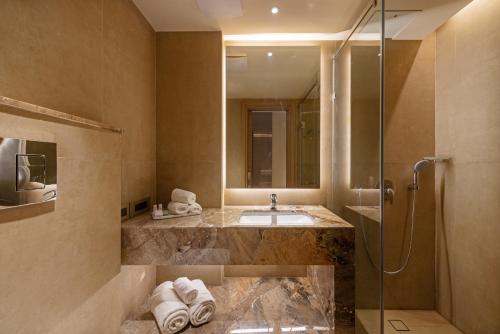 uma casa de banho com um lavatório e um chuveiro em Hotel Saket 27 em Nova Deli