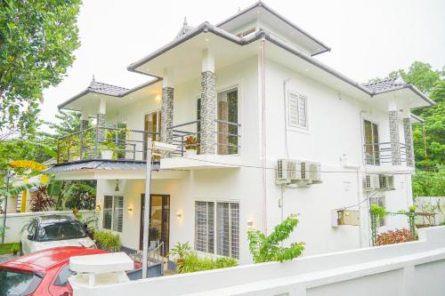 a house with a red car parked in front of it at Oceana Hills Residency in Alleppey