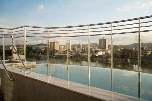 a swimming pool with a view of a city at Hotel Atlas in Sete Lagoas