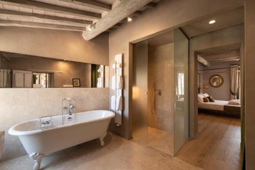 a bathroom with a tub and a bedroom at Drogheria e Locanda Franci in Montalcino
