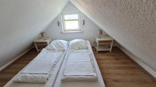 a bed in a room with two tables and a window at Rehbrook in Süsel