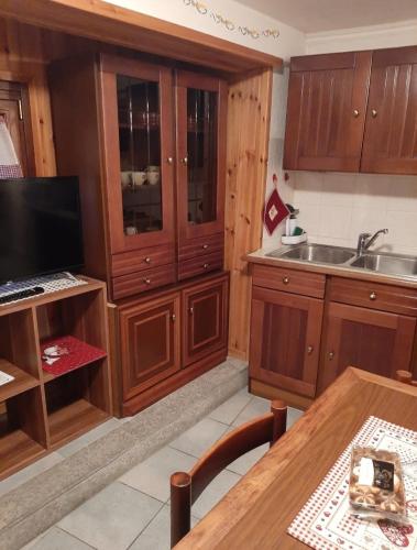 a kitchen with wooden cabinets and a wooden table at Casa Chiara in Nus