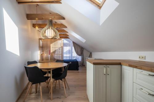 uma cozinha e sala de jantar com mesa e cadeiras em Nida Urbas Hill Apartments em Nida