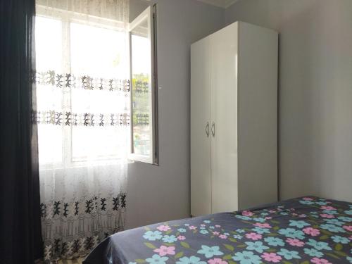 a bedroom with a bed and a dresser and a window at Shapatava ApartHotel in Batumi